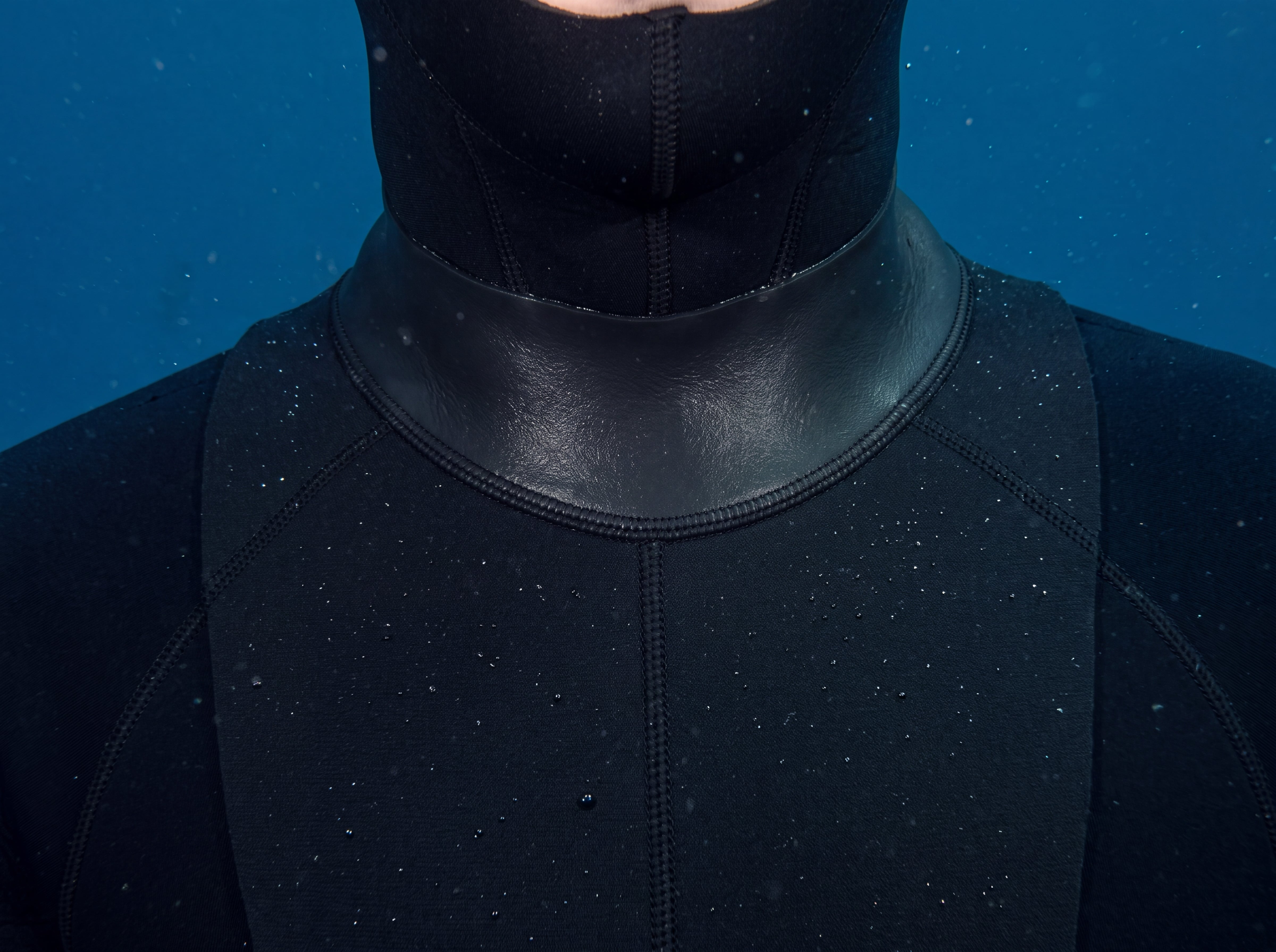 Close view of the Tilos 3mm Neoprene Dive Hood bib and glideskin neck seal being worn by a diver underwater